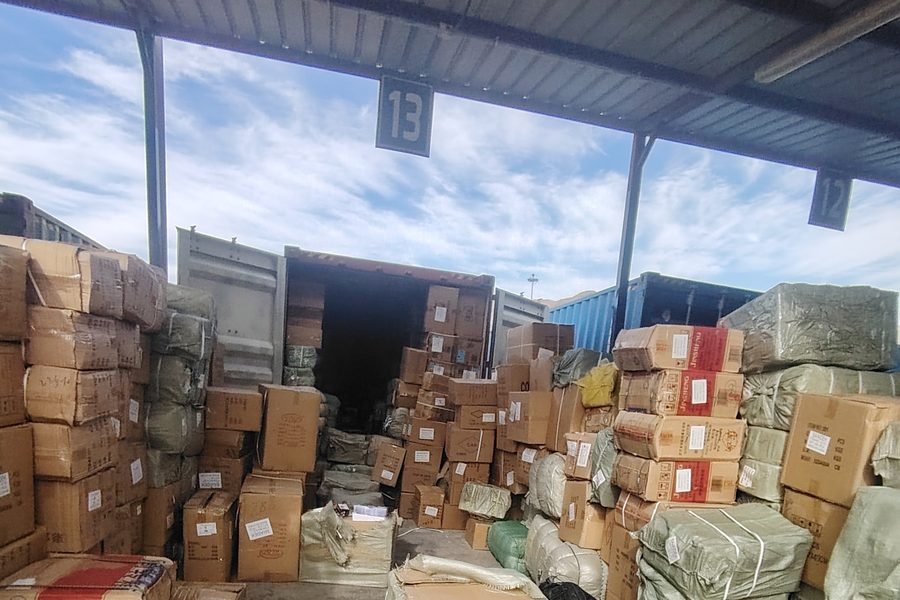 The customs yard at Aqaba Port — a container open at the inspection bay, cargo stacked awaiting examination
